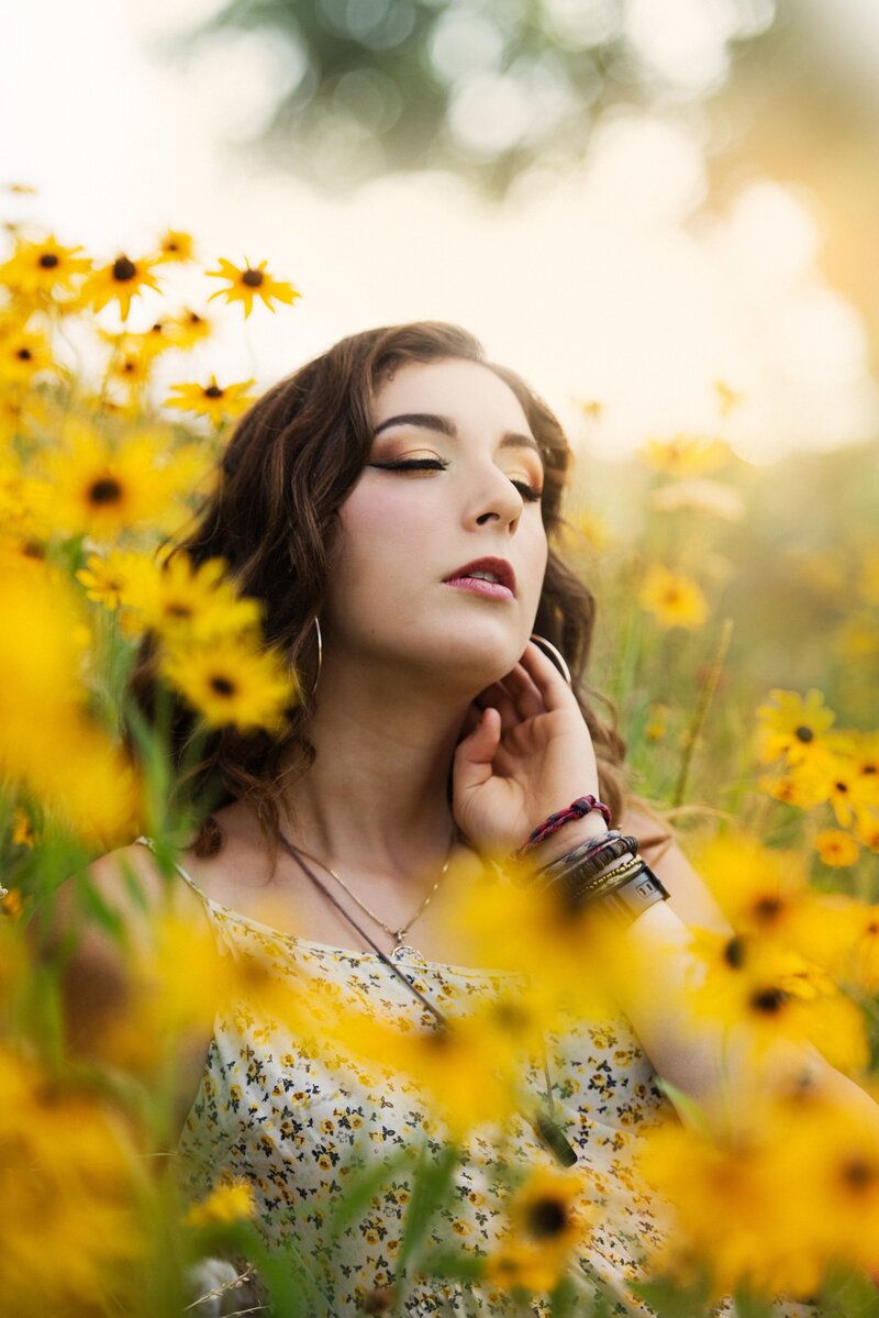 senior photo of girl in field of yellow flowers
