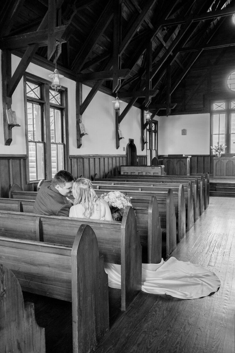 Couple smiling at each other in church pew — Madison Abernathy Photo