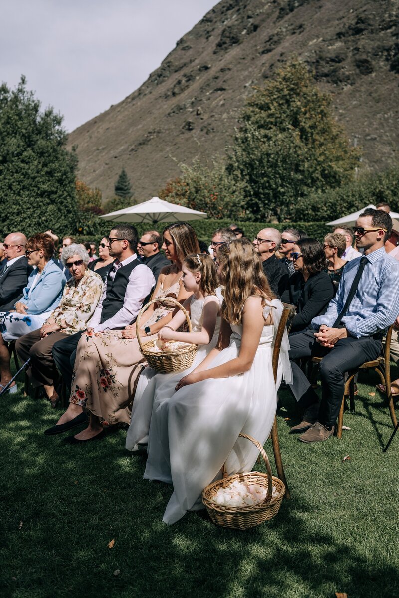 guests sit in the sunshine in front of remarkable mountain range in queenstown