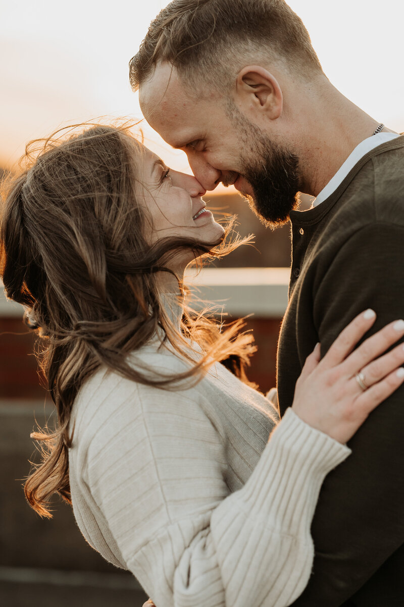 man and woman at golden hour nose to nose smiling at each other