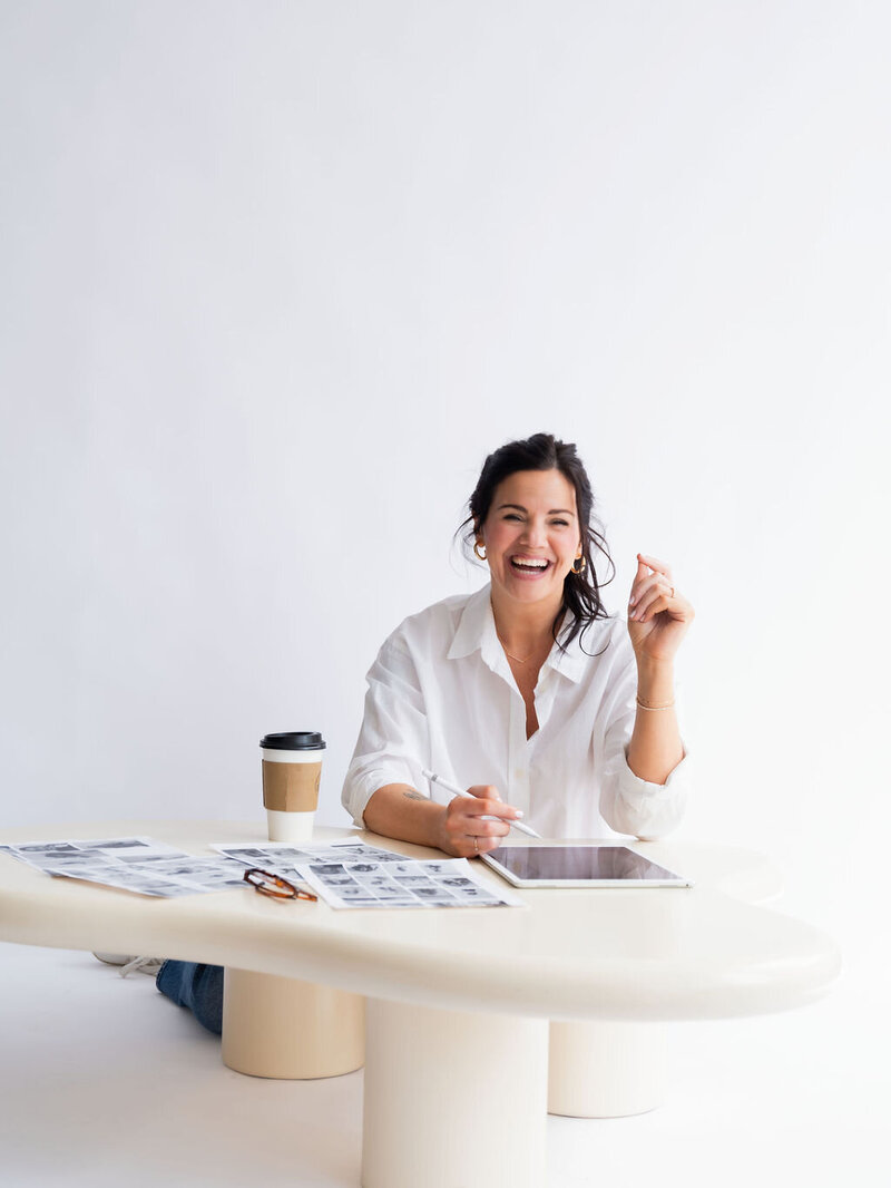A woman holding a phone, looking directly at you