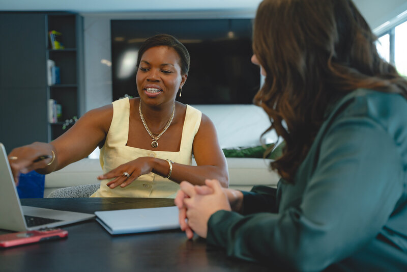 Black career coach for professional women working at black table with client