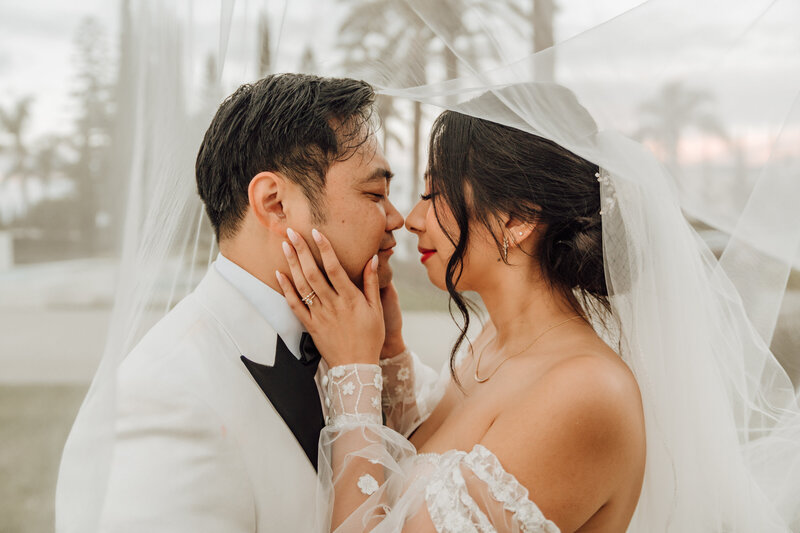 Engaged Couple laying down in the sand taken by Orange County wedding photographer Mikey Mora Photography