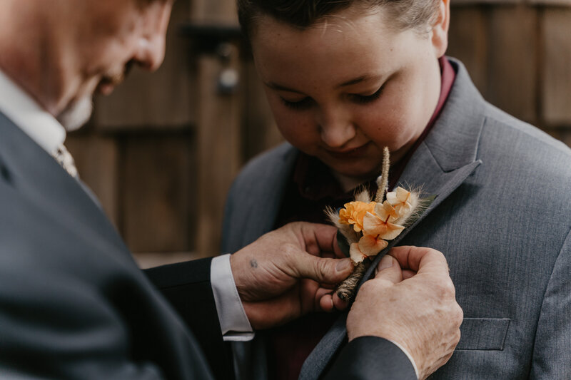 Father pinning son's boutonniere.