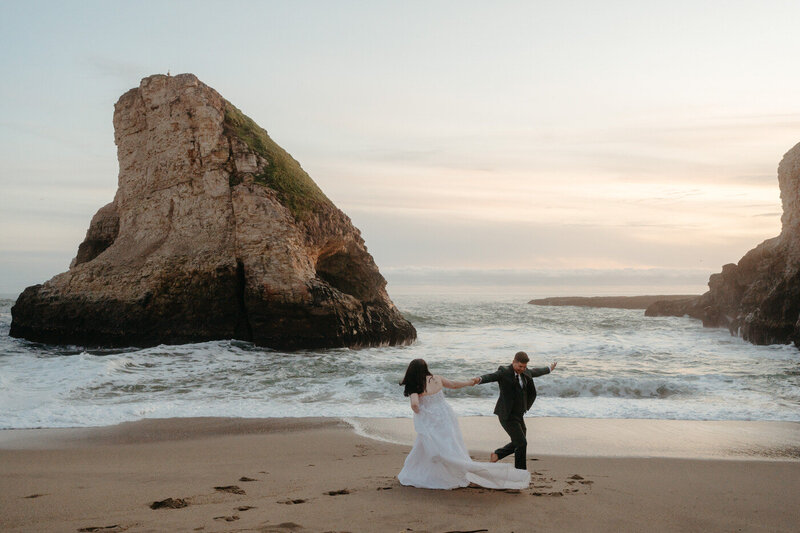 Couple runs around the beach after their Shark Fin Cove Wedding