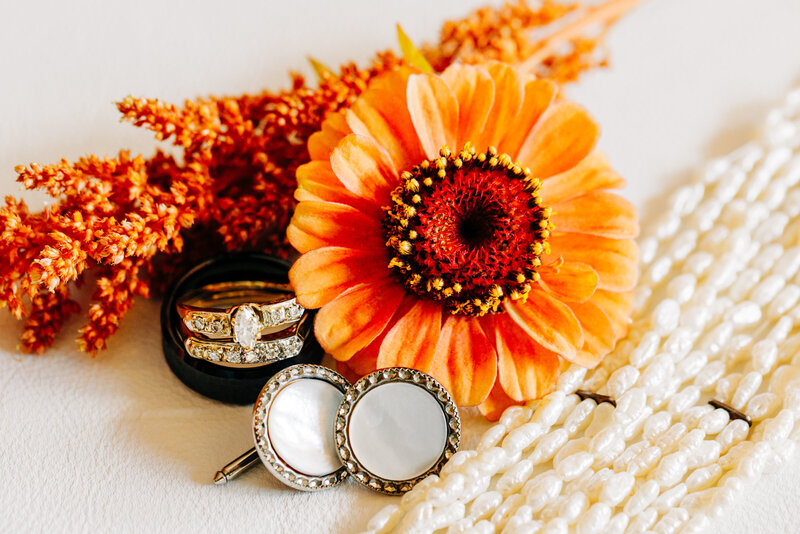 Wedding detail photo of rings, cufflinks, jewelry, and flowers