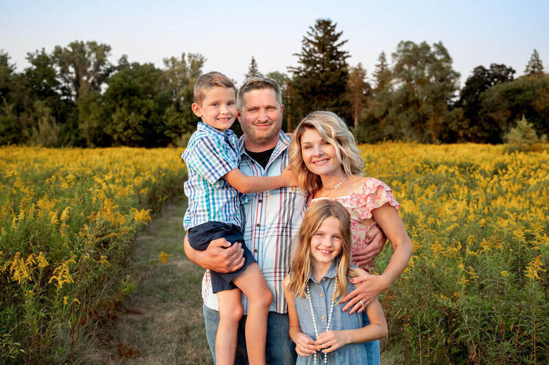 Family standing in a field of yellow flowers in Canton, Michigan park