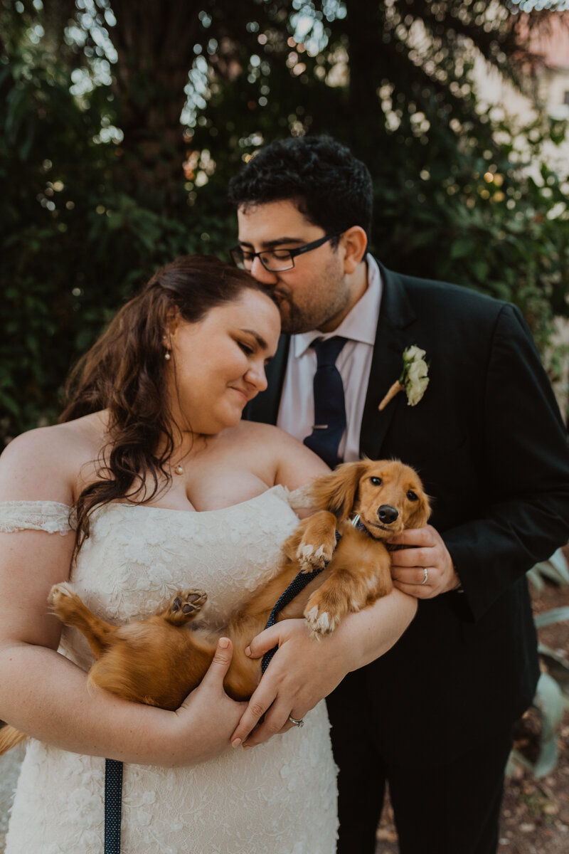 A couple poses with their dog at their wedding in St. Augustine, Florida
