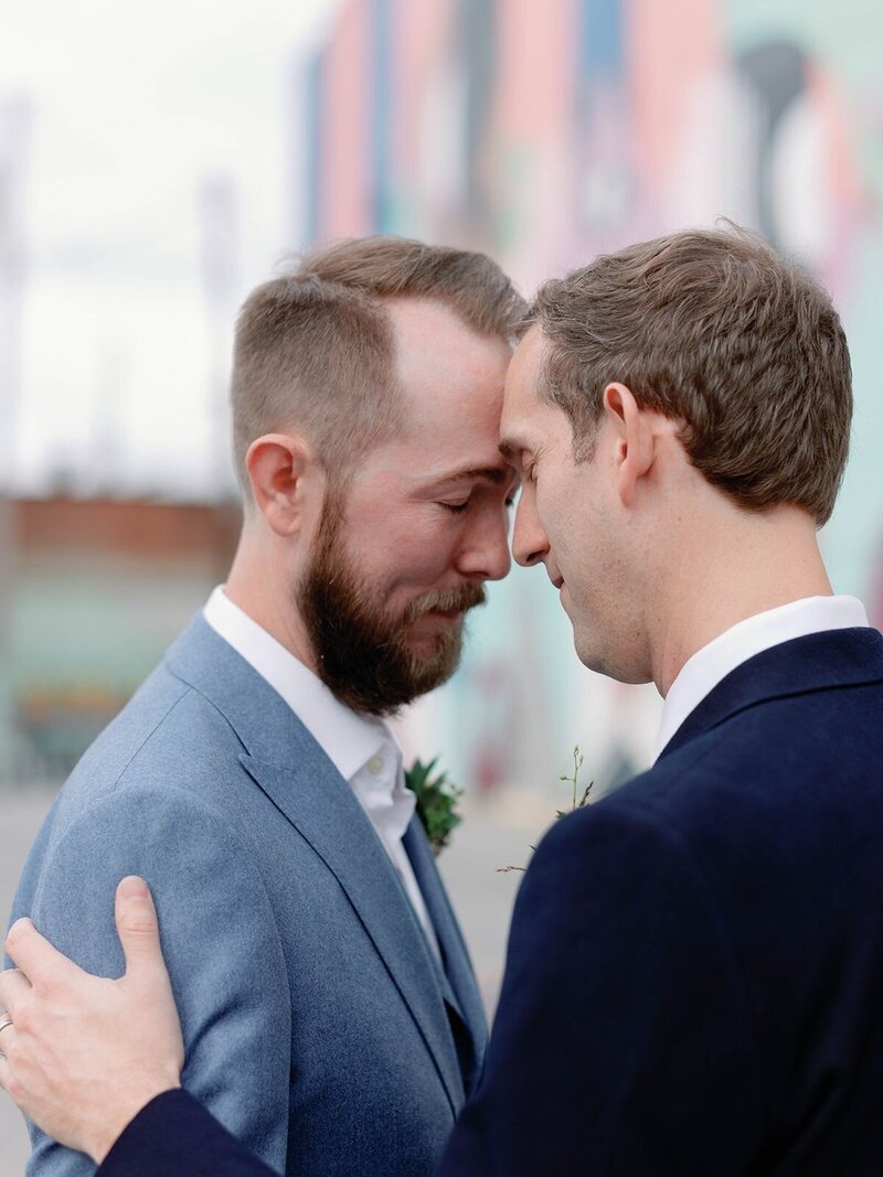 Two grooms embracing during their same sex marriage at outdoor wedding venue in Baltimore