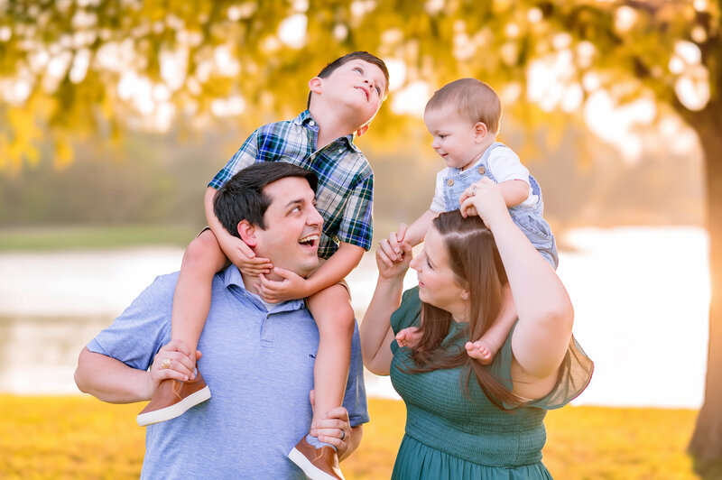 Parents playing with their two young sons during a golden hour family session in Prosper, Texas, photographed by Jennifer L. Kirk Photography.
