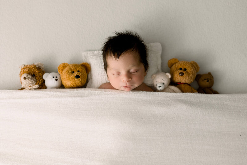 Baby girl newborn portrait in an Erie Pa photography studio laying on a bed