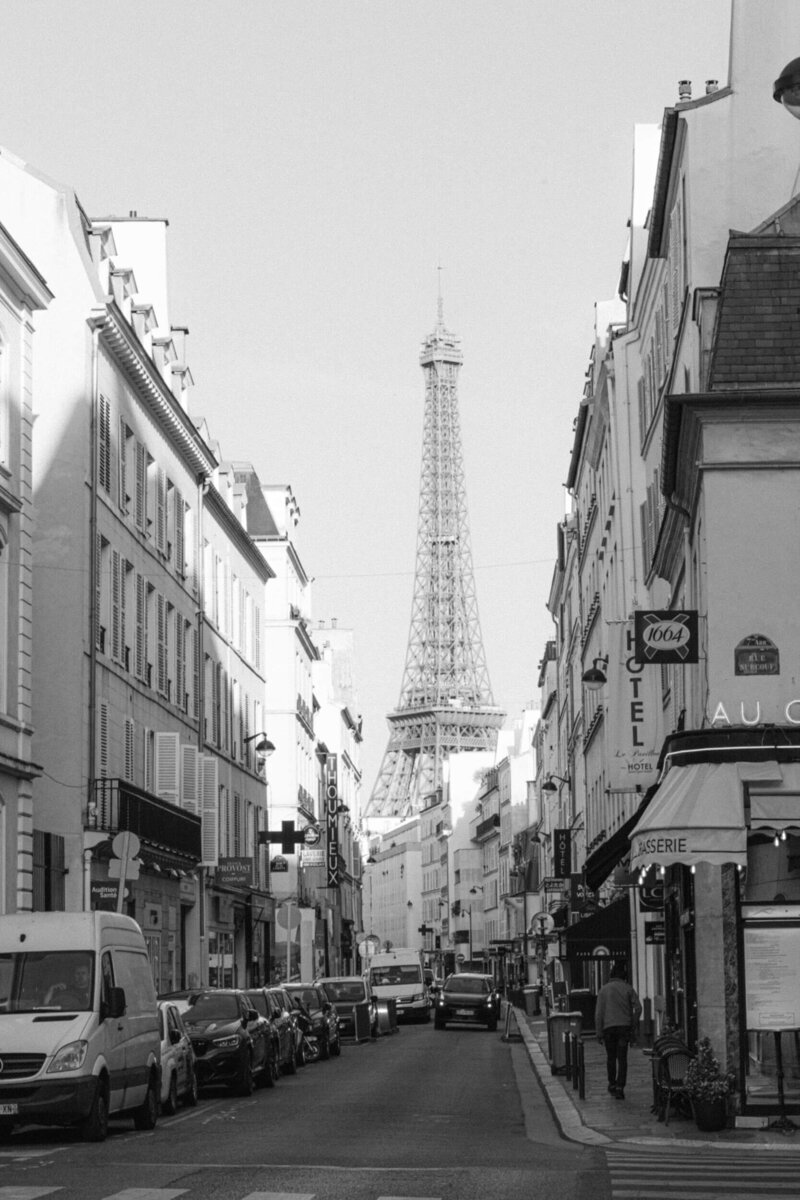 black and white image from the streets of paris looking up at the Eiffel tower