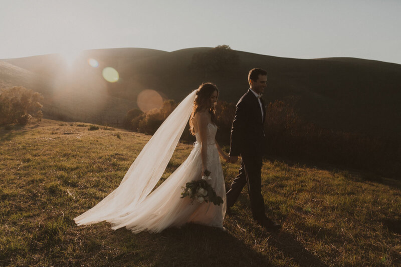 bride and groom walking on hillside