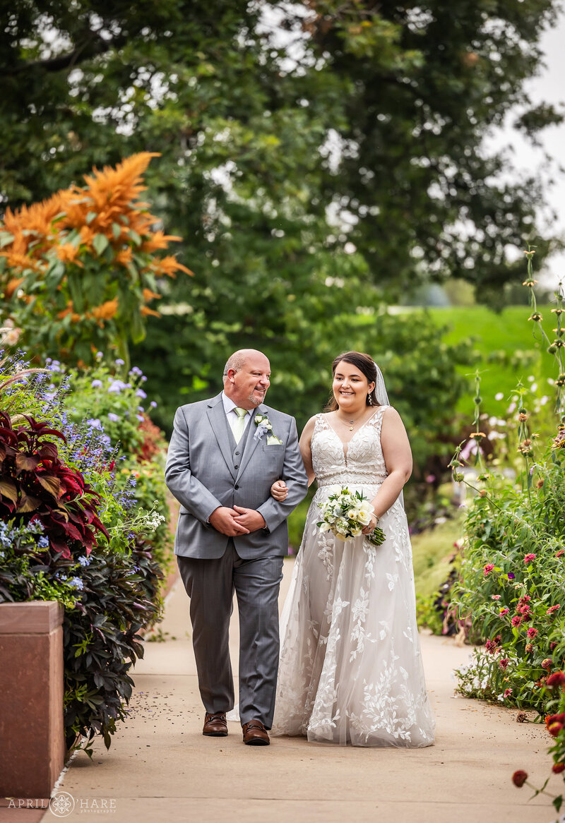 A father walks his daughter down the aisle on her wedding day at the Annuals Garden at Denver Botanic Gardens
