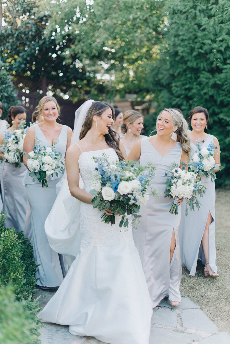 The bride looking at her wedding party while walking on her wedding day at Park Crest Events