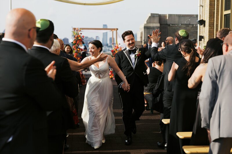 A newlywed couple coming down the aisle at their Bok wedding.