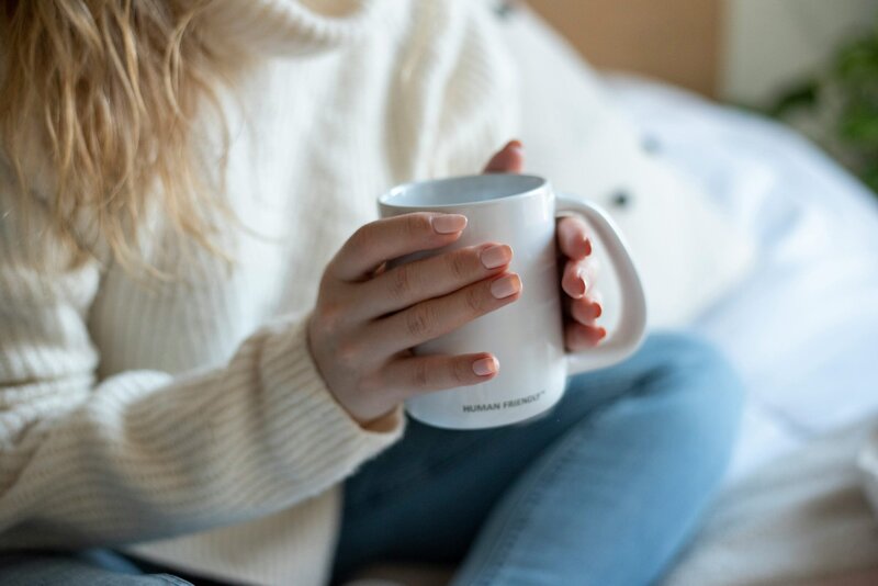 Woman holding curvd coffee cup