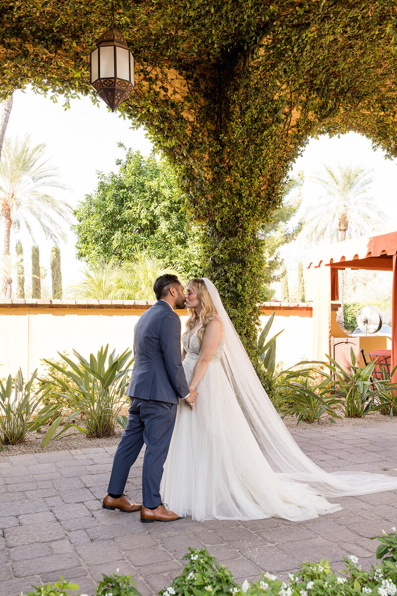 Couple kissing under ivy covered hallway