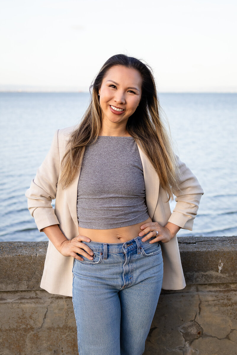 A Bay Area family photographer behind Ellobelle Photography smiling confidently by the water.