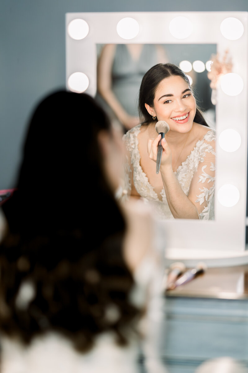 Bride applying makeup on her wedding day, capturing the quiet elegance and anticipation before saying ‘I do’.