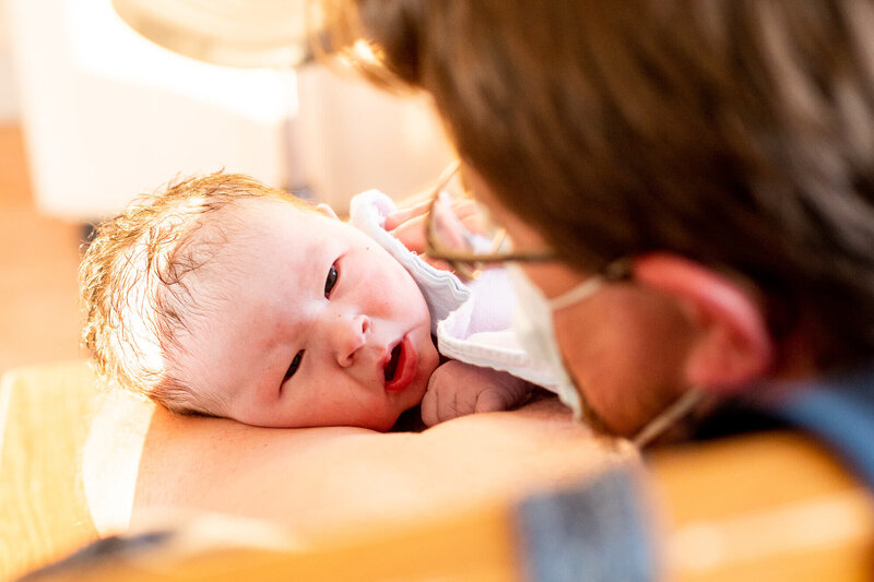 Newborn being rocked by father during golden hour at St. Michael’s Hospital in Toronto, after a long and powerful labour