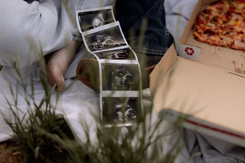 couple sitting on floor in studio holding baby