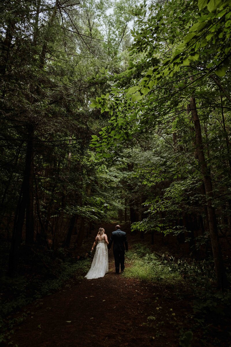 Newlywed couple walking a forest trail during their elopement