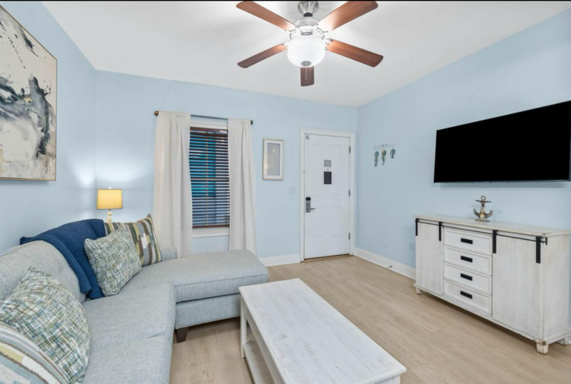 gray couch with white coffee table and hardwood floors