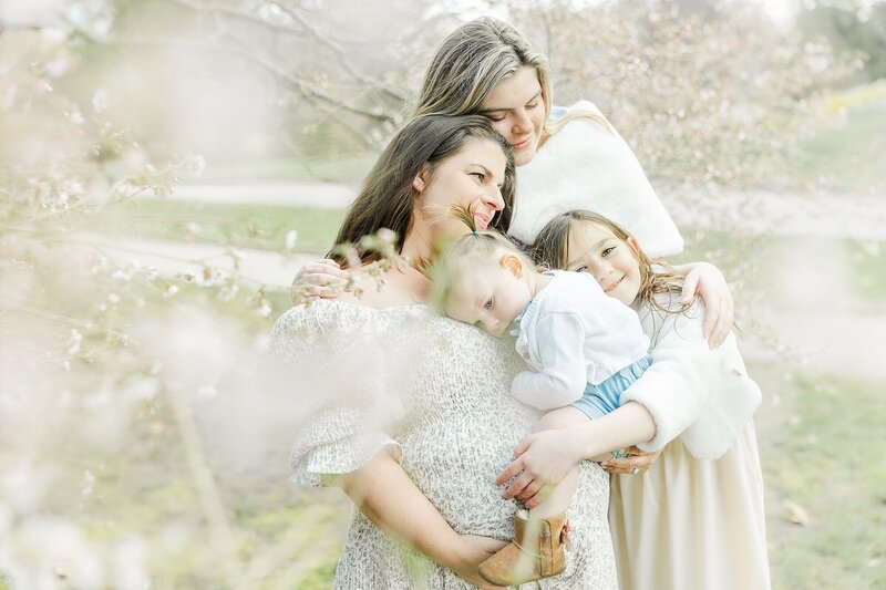 mom kisses daughter during spring photo session  in Wellesley Massachusetts with  Sara Sniderman Photography