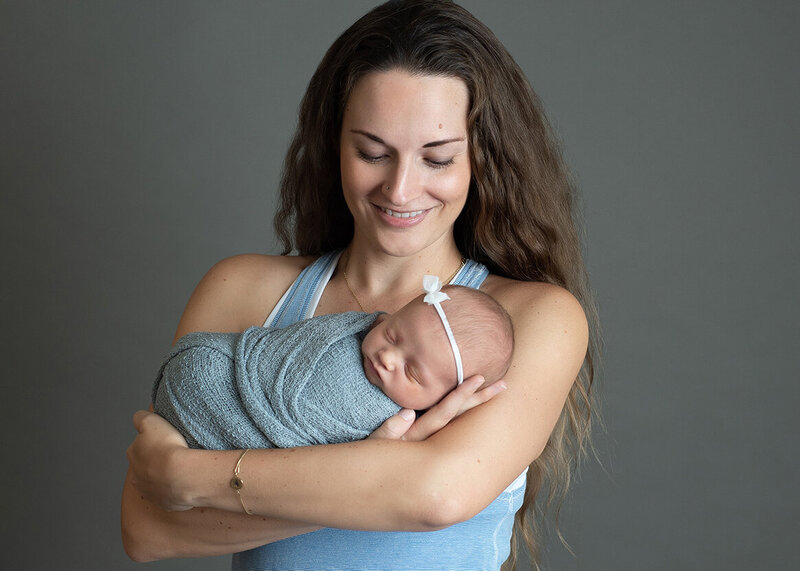 A professional newborn photo of a beautiful mother and baby