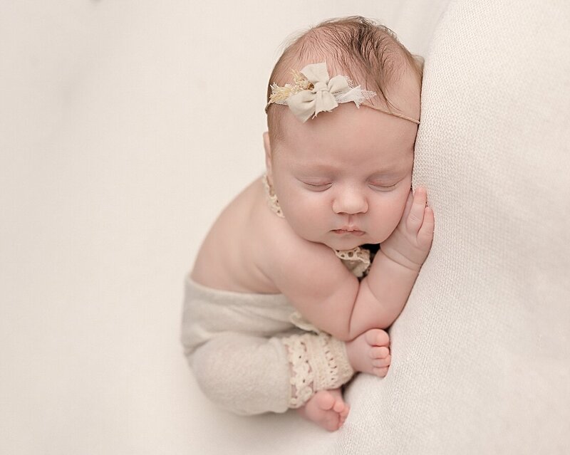 baby newborn girl wearing cream romper in Beaverton Oregon Photography session