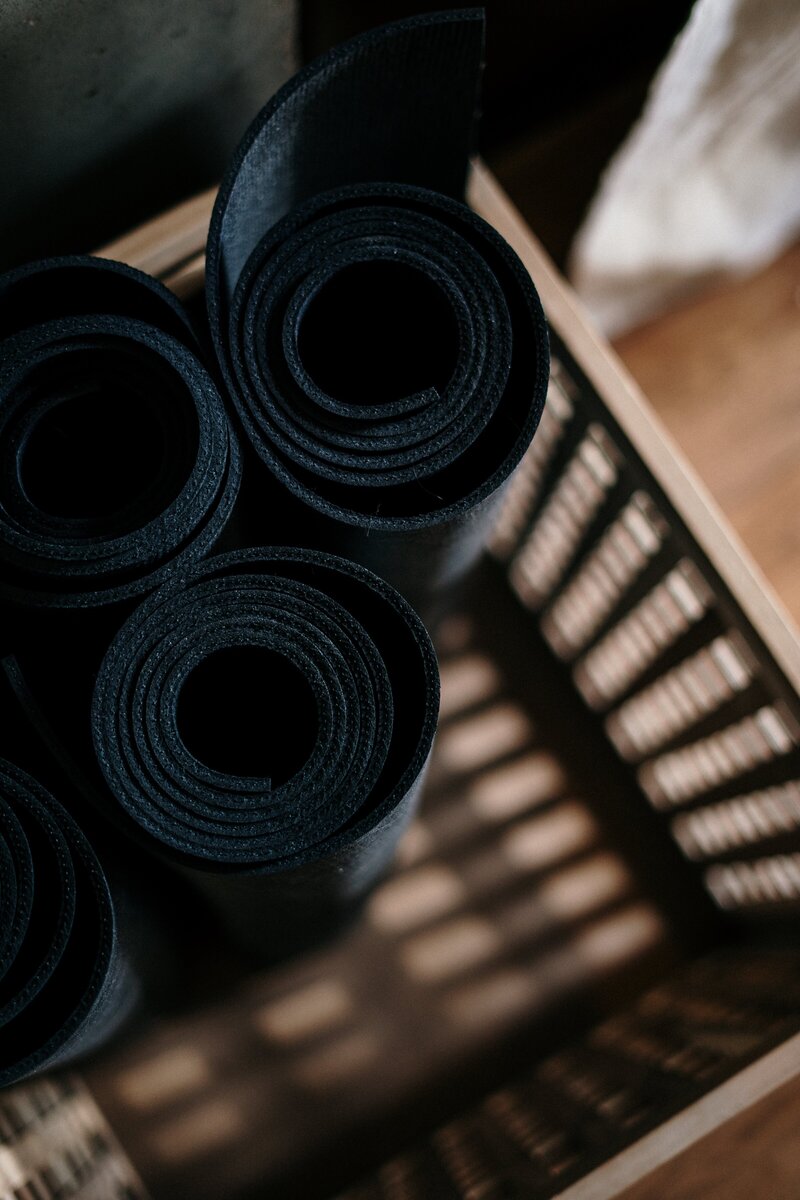 Close up image of rolled up yoga mats in a basket