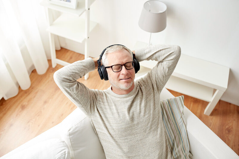 happy-man-in-headphones-listening-to-music-at-home-PRU7NLA