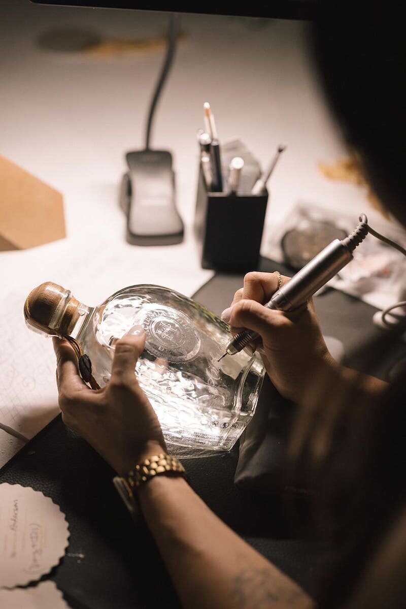 Close up of a tequila bottle being hand-engraved by Cat Lauren Calligraphy