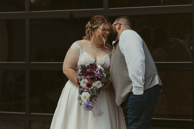 photo of man whispering in woman's ear