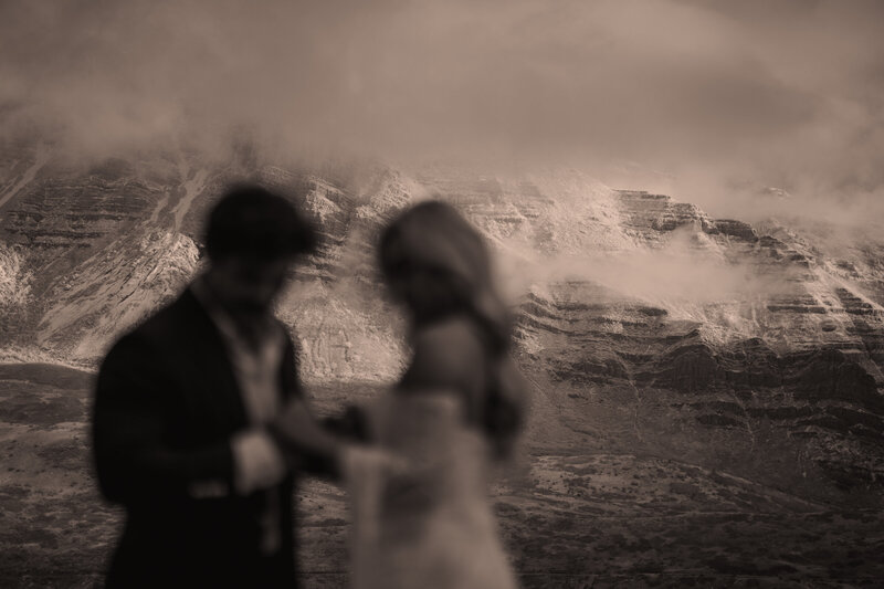 Elopement couple in green wedding clothes hold hands with the Khyv mountains in the background.