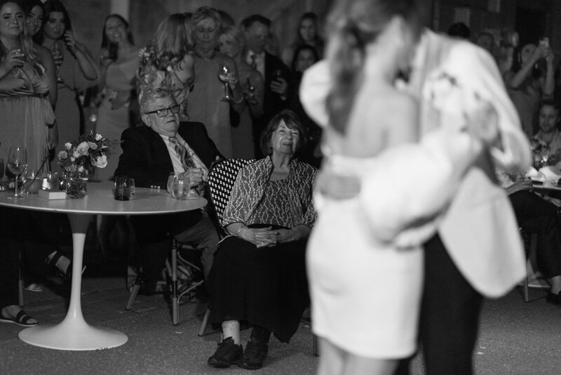 A woman smiles with hands on her hips.
