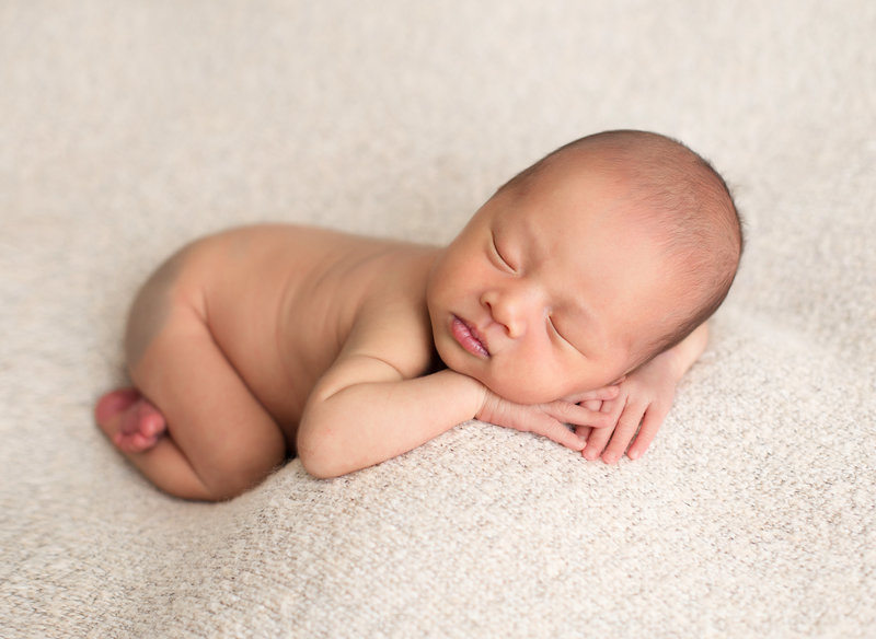 newborn on tan blanket