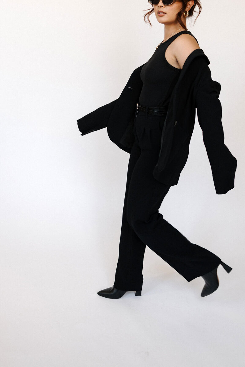 Confident professional in a tailored black suit, symbolizing the empowerment and sophistication that House of Virtua Mind brings to your Dubsado workflows with custom CRM set-up services
