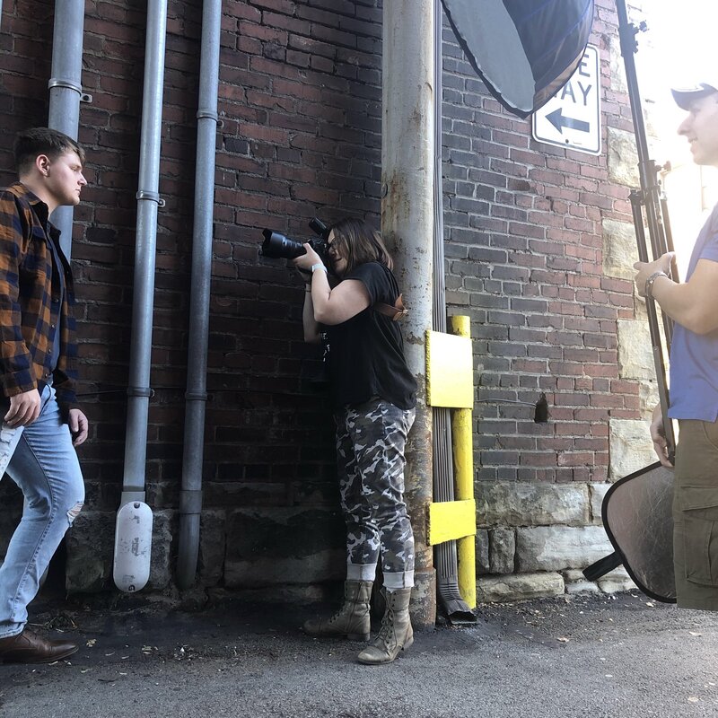 Photo shoot of senior boy leaning against pipes in alley