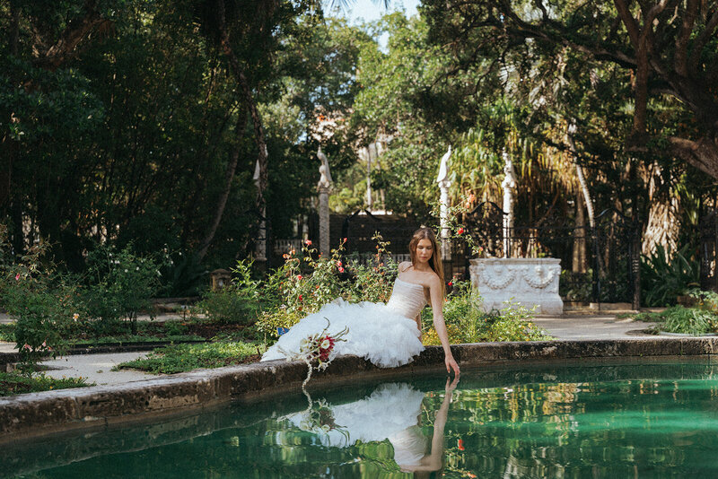 bride sitting by water in miami wedding photos captured by elsie goodman, a destination and italy wedding photographer