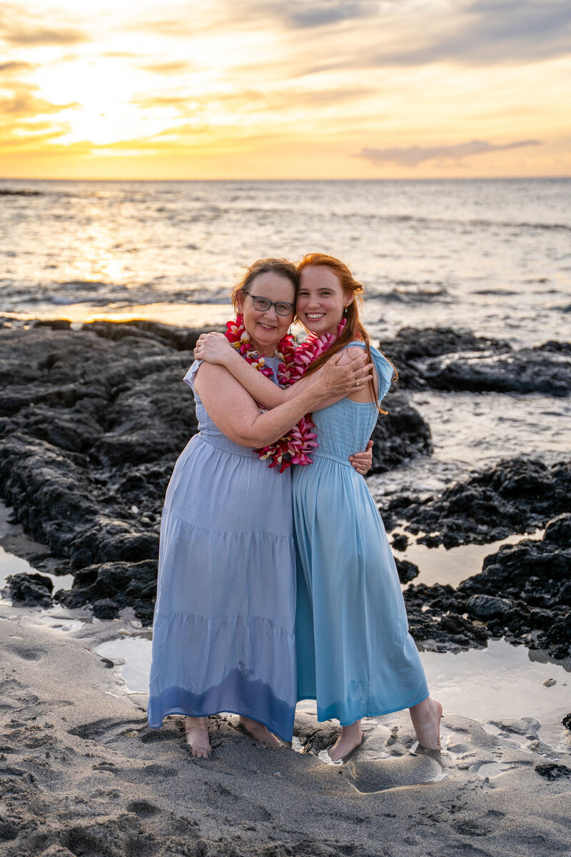 Two girls hugging for family photos on the beach of Big Island Hawaii