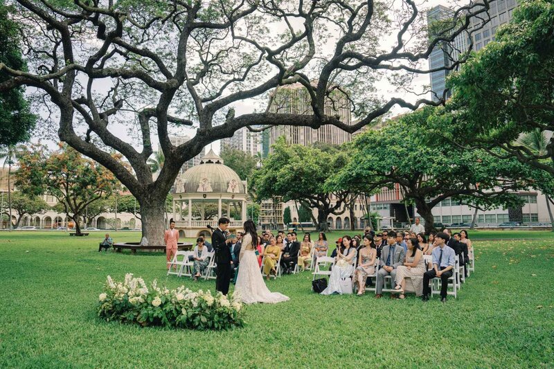 Groom holds bride's dress.