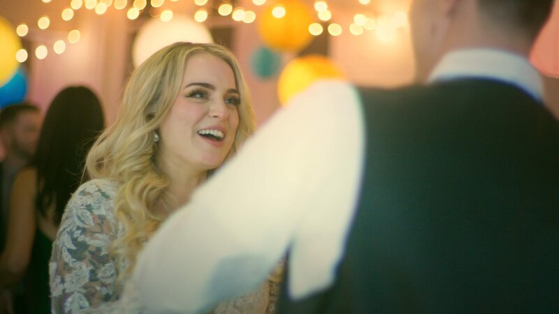 A woman with twinkle lights behind her at a wedding.