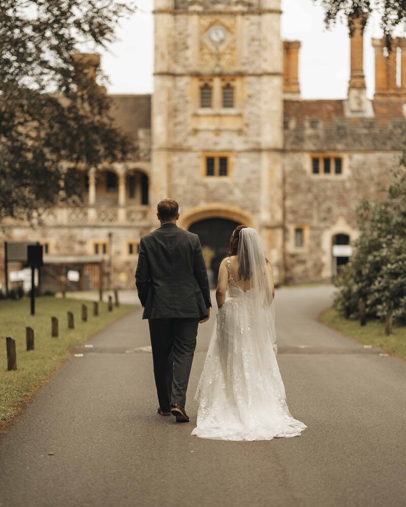 Bride and groom walking down the lane at Rhinefield House