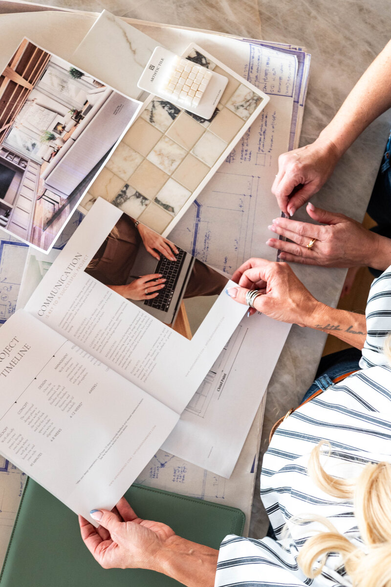 Interior designer showing blueprints and house plans to client