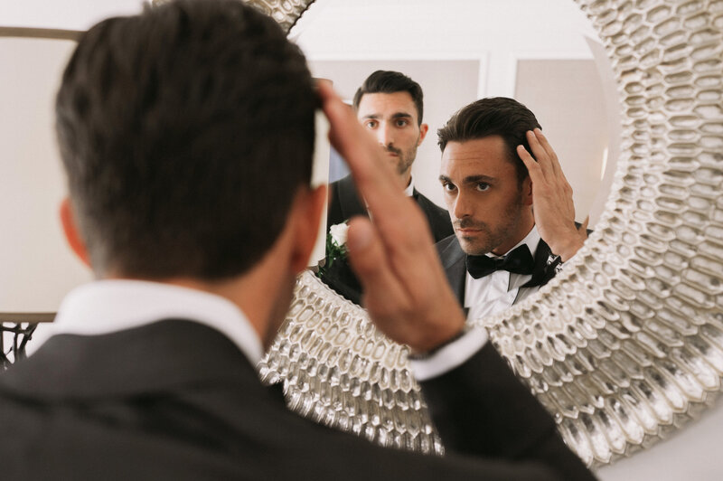 Groom looking at the mirror and fixing his hair