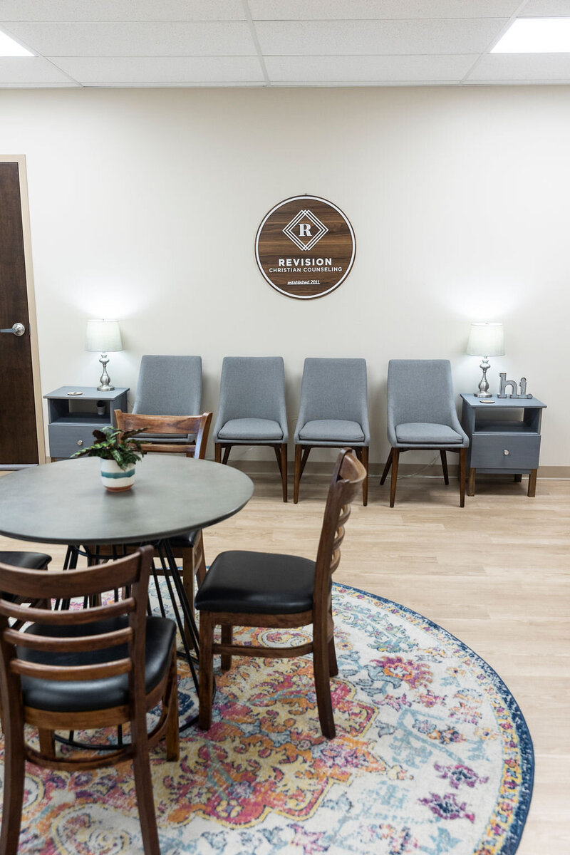 Room with chairs agains that wall and table and chairs in the middle