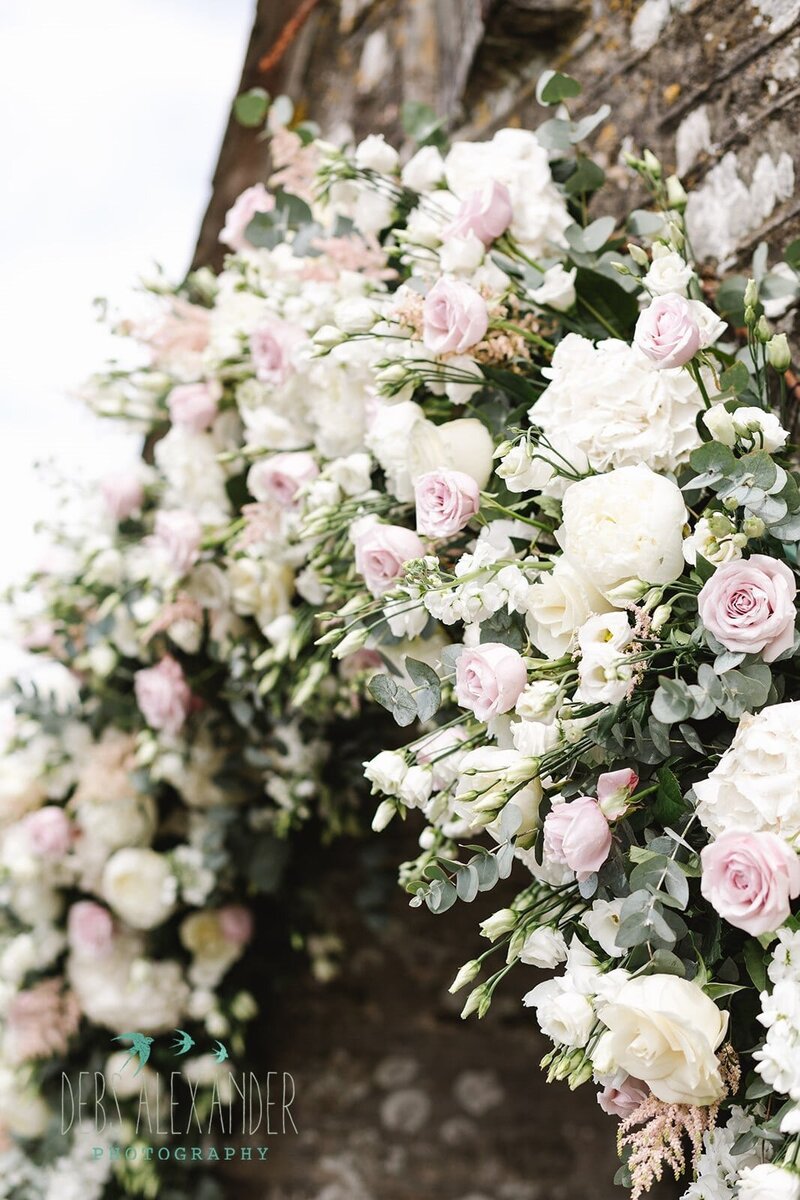 Church arch of blush roses and white flowers for a Cornwall wedding