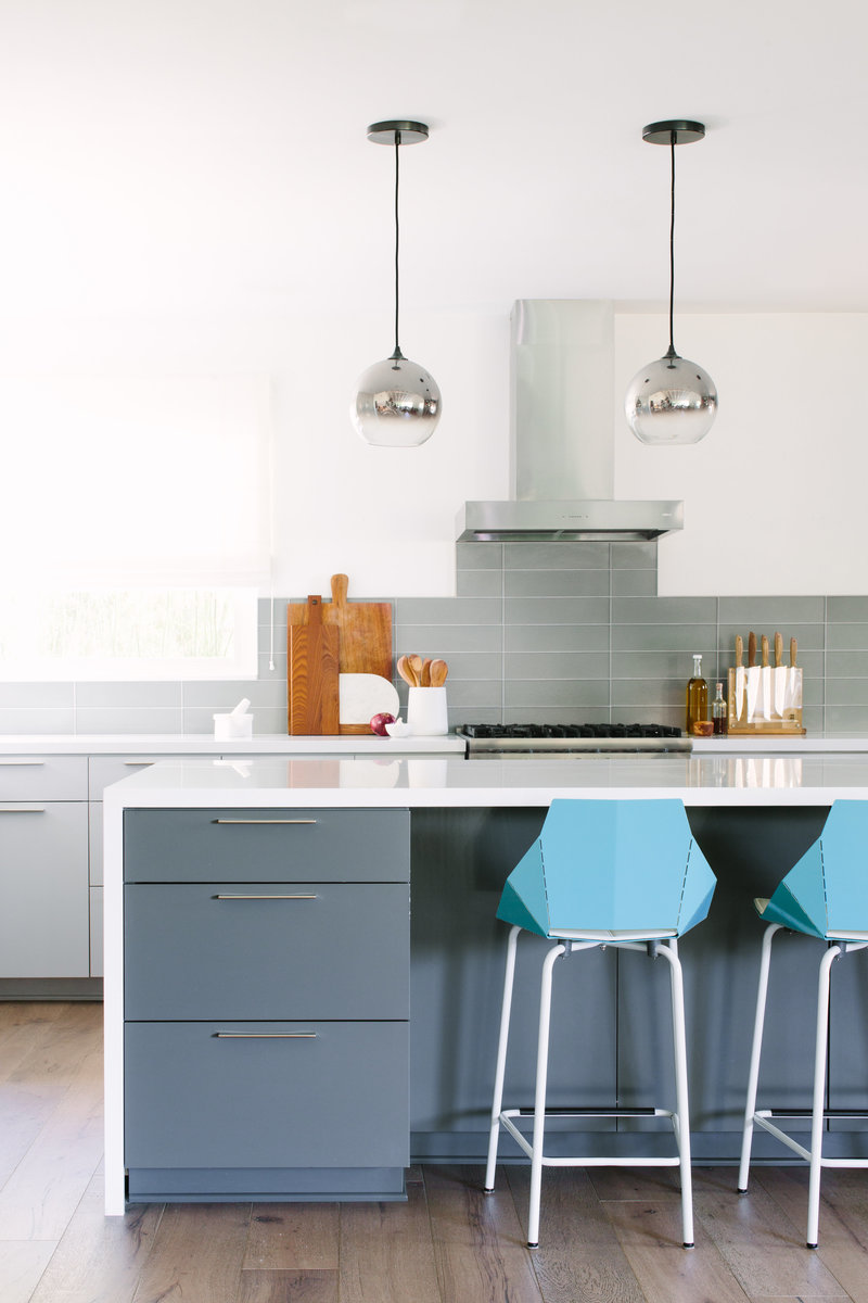 Grey and white modern kitchen with blue Blu Dot counter bar stools